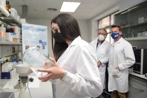 En la imagen, Sonia Olmos realizando una filtración en el laboratorio. Al fondo, sus directores de tesis.
